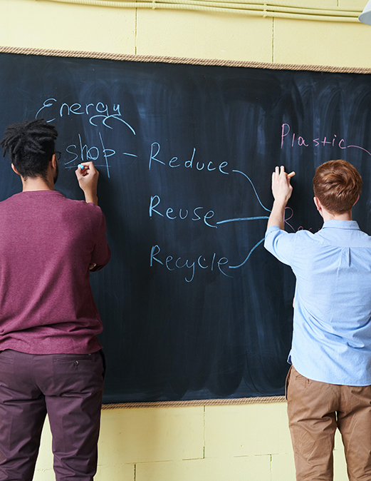 students writing on chalkboard